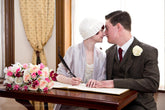 Sealed with a kiss, the bride and groom in their 1920s outfits. Bride wearing Anna Chocola 1920s cloche hat.